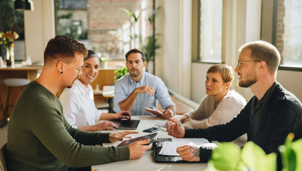 Une équipe d'hommes et de femmes que discutent pour développer une entreprise sur internet
